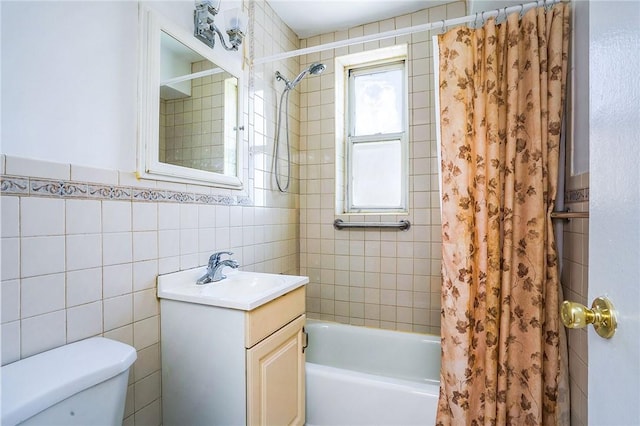 full bathroom with vanity, toilet, tile walls, and shower / tub combo with curtain