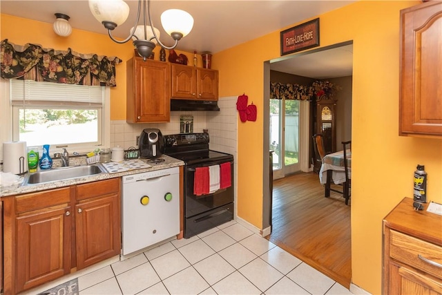 kitchen featuring light wood-type flooring, tasteful backsplash, white dishwasher, sink, and electric range