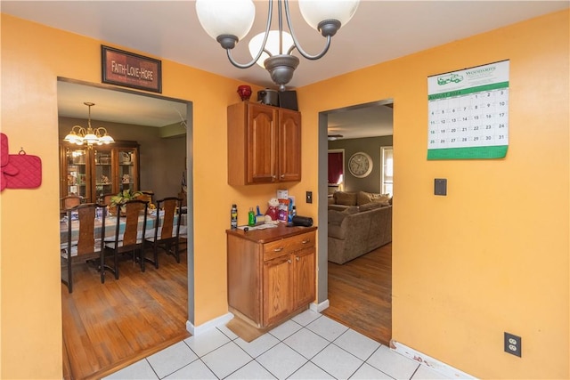 kitchen with light hardwood / wood-style flooring, pendant lighting, and a notable chandelier