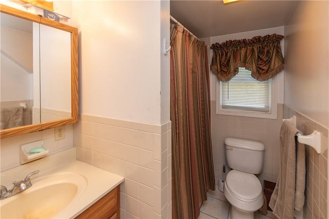 bathroom with tile patterned floors, vanity, tile walls, and toilet