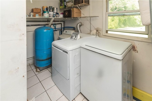 clothes washing area with washer and dryer and light tile patterned flooring