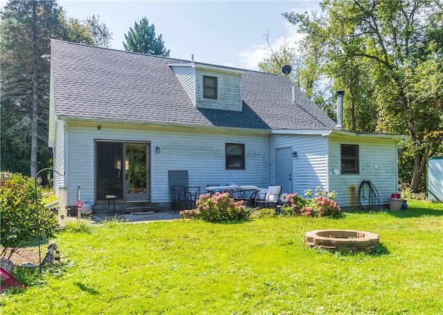 back of house with a yard and an outdoor living space with a fire pit