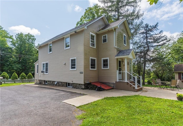 view of side of property featuring a lawn and a patio