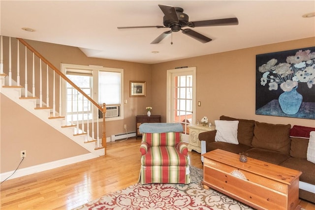 living room with ceiling fan, light hardwood / wood-style floors, baseboard heating, and a wall unit AC