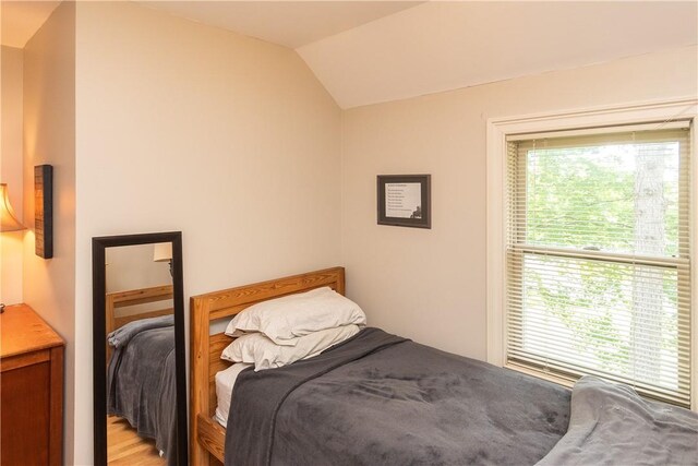 bedroom featuring light hardwood / wood-style flooring and vaulted ceiling