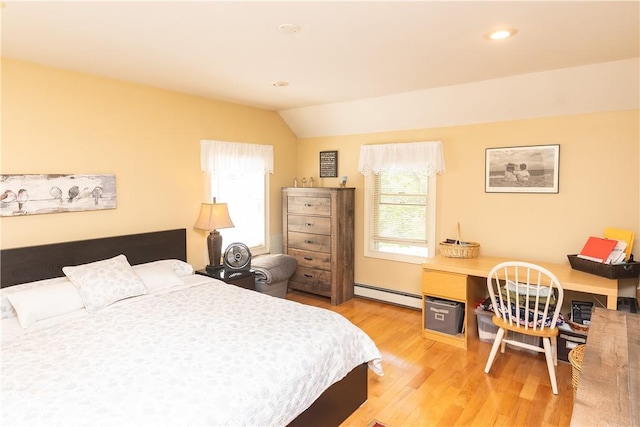 bedroom with lofted ceiling, wood-type flooring, baseboard heating, and multiple windows