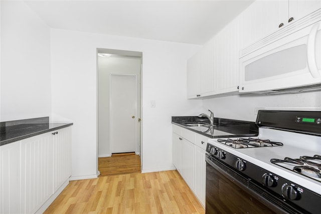 kitchen featuring white cabinets, white appliances, light hardwood / wood-style floors, and sink