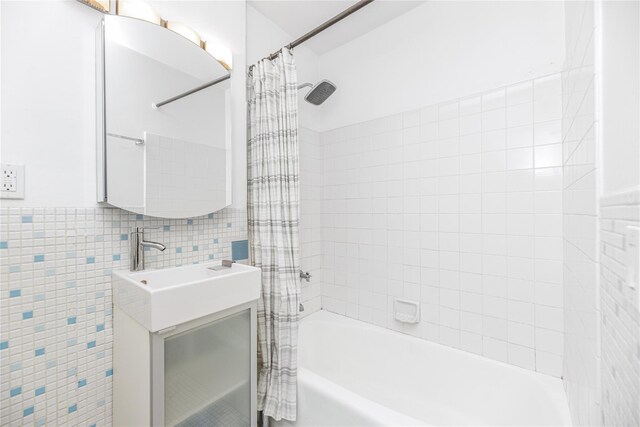 bathroom featuring vanity, shower / bathtub combination with curtain, and tile walls