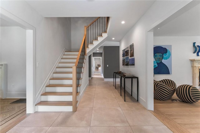 staircase featuring tile patterned floors and a high end fireplace