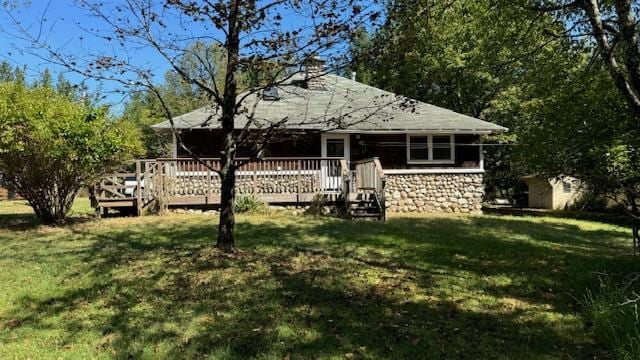 back of property with a yard and a deck