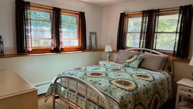 bedroom with multiple windows and a baseboard radiator