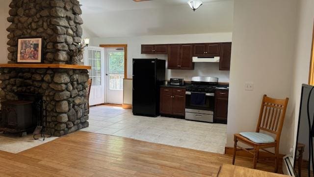 kitchen with gas stove, dark brown cabinetry, light hardwood / wood-style flooring, lofted ceiling, and black refrigerator