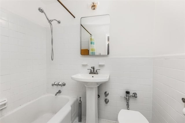 full bathroom with toilet, tile walls, shower / bath combo with shower curtain, and sink