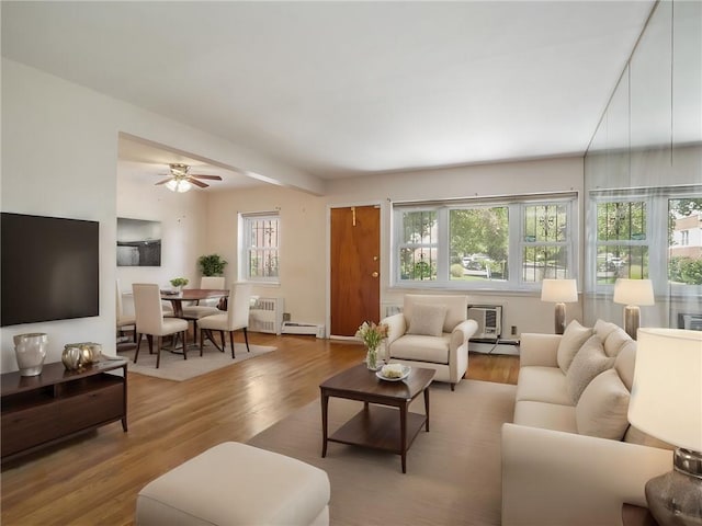 living room with ceiling fan, light hardwood / wood-style flooring, and a baseboard heating unit