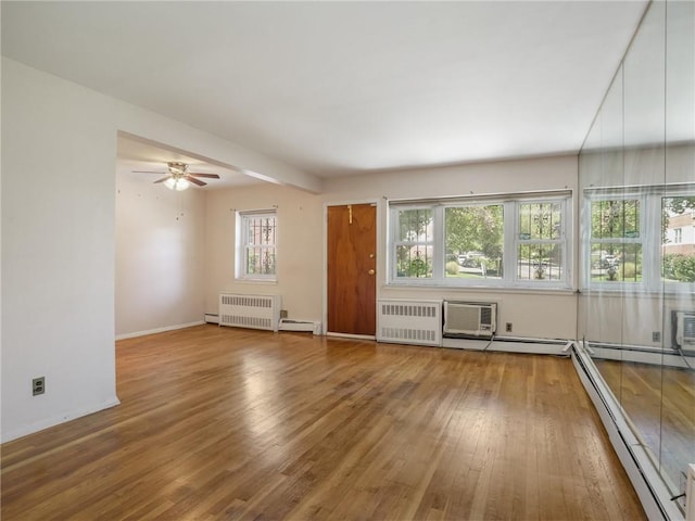 unfurnished living room featuring hardwood / wood-style floors, plenty of natural light, and radiator