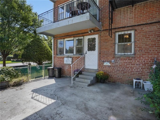 view of exterior entry with a balcony