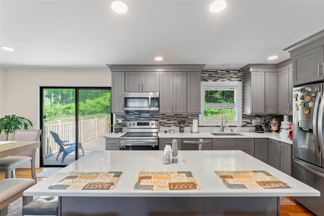 47 Riverside Rd, Newtown, CT 06482 - kitchen with appliances with stainless steel finishes, gray cabinets, a kitchen breakfast bar, recessed lighting, and ornamental molding
