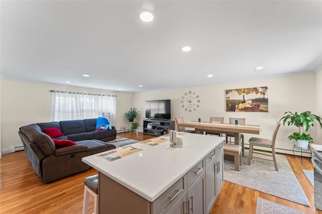 47 Riverside Rd, Newtown, CT 06482 - kitchen with baseboard heating, crown molding, a kitchen island, open floor plan, and light wood finished floors