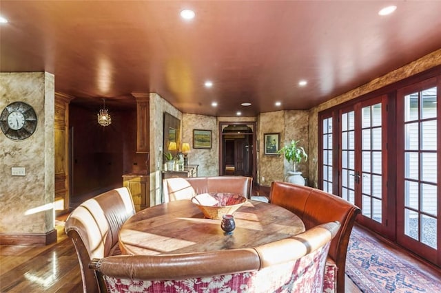 dining area featuring plenty of natural light, dark hardwood / wood-style flooring, and an inviting chandelier