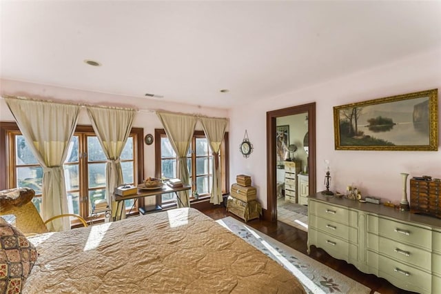 bedroom featuring dark hardwood / wood-style flooring and multiple windows