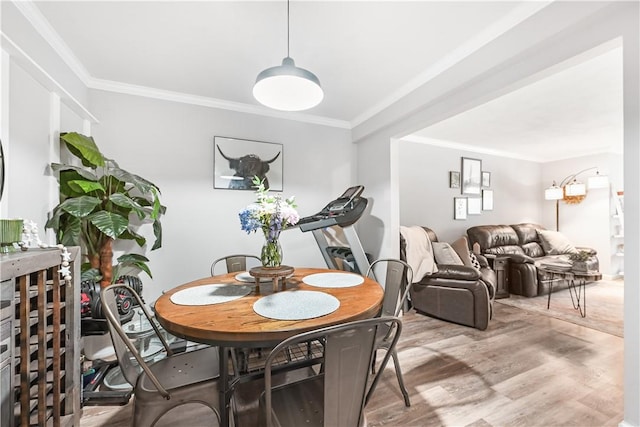 dining area featuring light wood-type flooring and ornamental molding