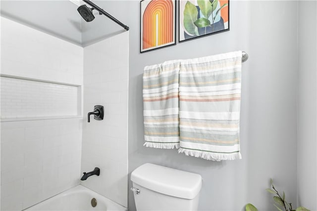 bathroom featuring toilet and tiled shower / bath