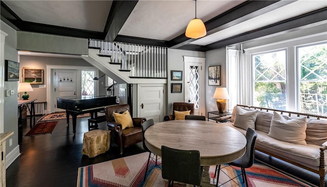 dining space with beamed ceiling, ornamental molding, plenty of natural light, and dark wood-type flooring