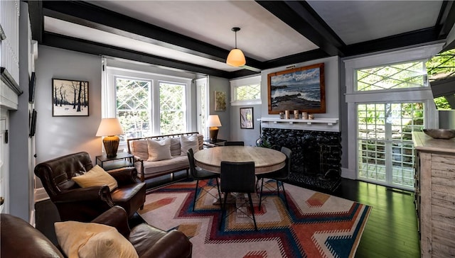 dining space with a fireplace, dark hardwood / wood-style flooring, and beamed ceiling