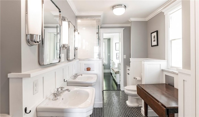 bathroom with dual sinks and ornamental molding