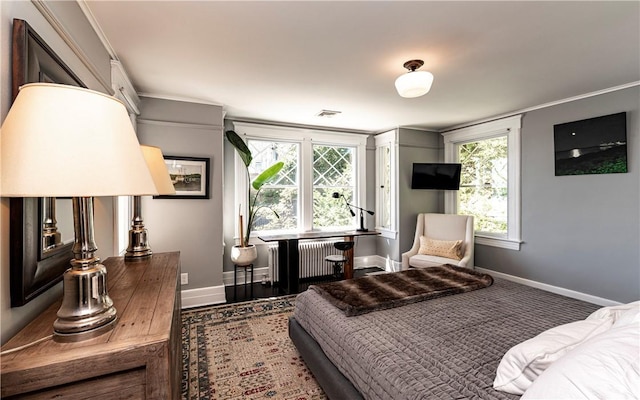 bedroom featuring multiple windows, ornamental molding, wood-type flooring, and radiator