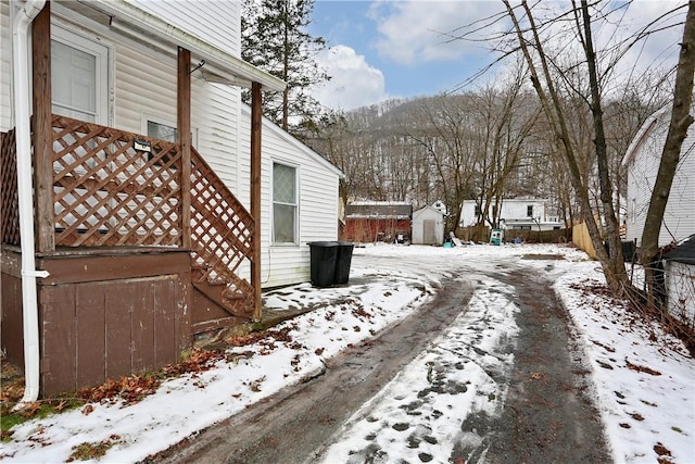 view of snowy exterior with a shed