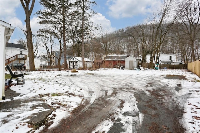 yard covered in snow featuring a storage unit