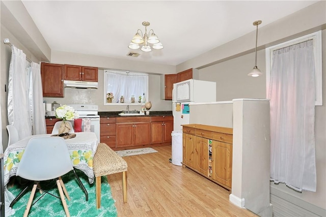 kitchen with light wood-type flooring, sink, a notable chandelier, white electric range, and hanging light fixtures