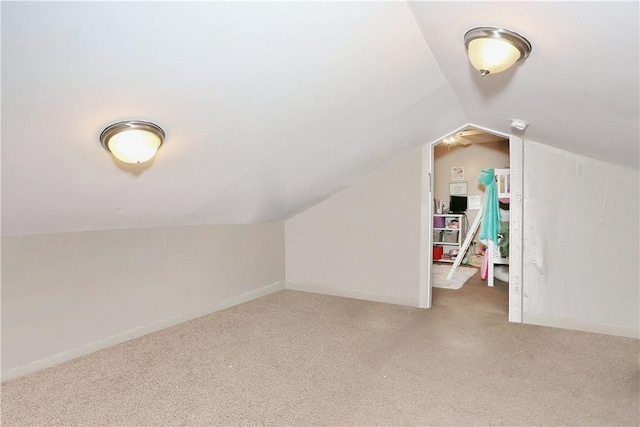 additional living space with lofted ceiling and light carpet