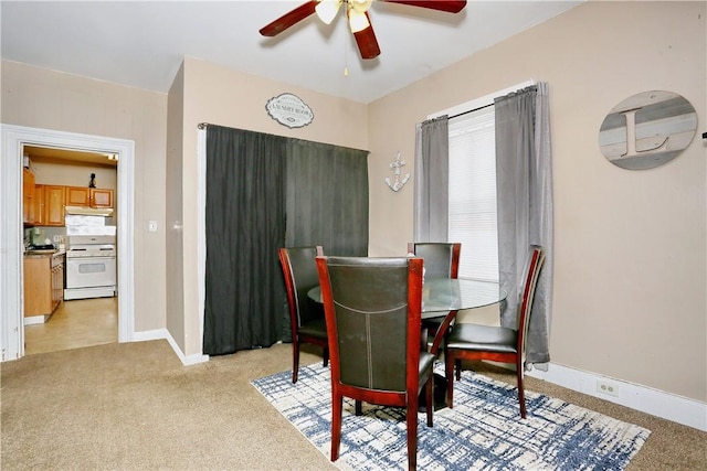 carpeted dining space with ceiling fan