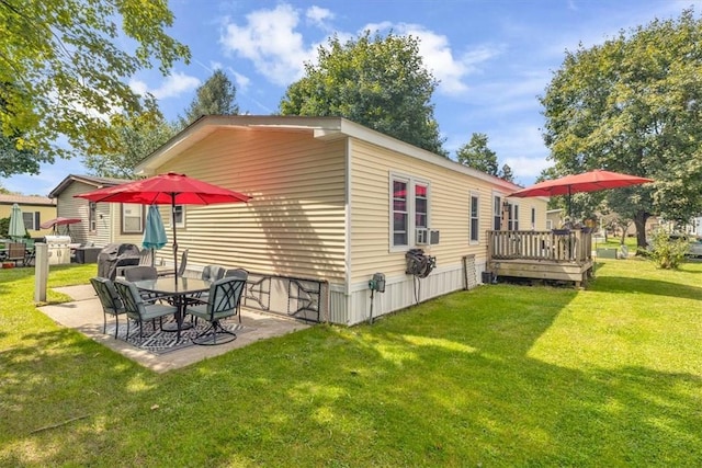 view of home's exterior featuring a patio area, a yard, and a wooden deck