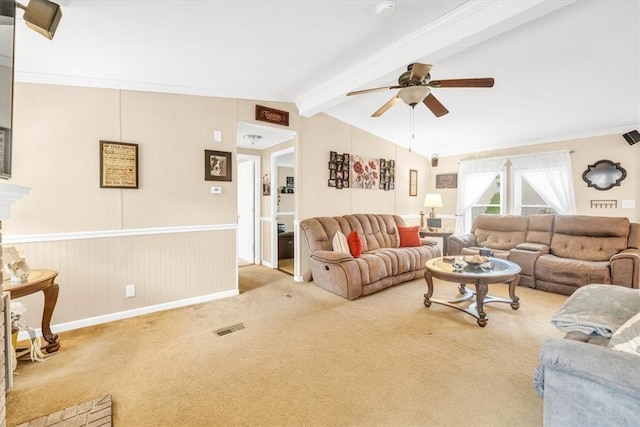 carpeted living room with ceiling fan, lofted ceiling with beams, and ornamental molding