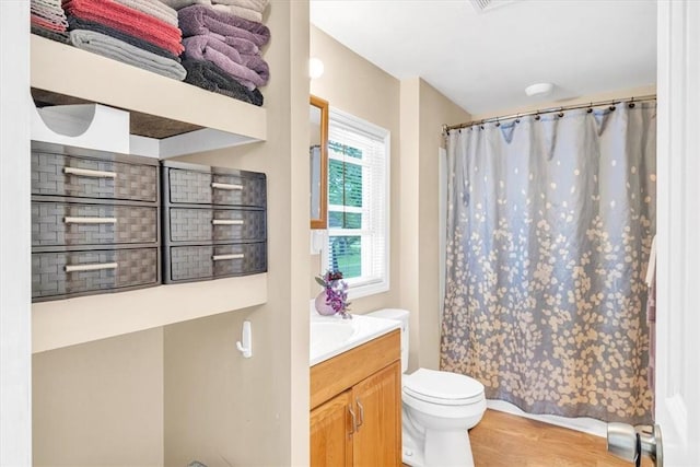 bathroom featuring curtained shower, vanity, wood-type flooring, and toilet