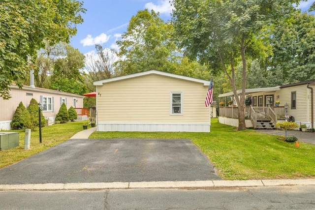 view of property exterior with a lawn and a deck