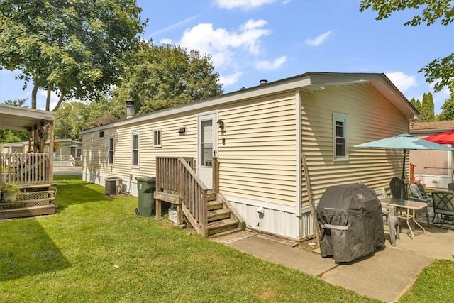 rear view of property with a yard and cooling unit