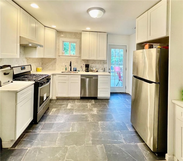 kitchen featuring decorative backsplash, appliances with stainless steel finishes, white cabinetry, and sink