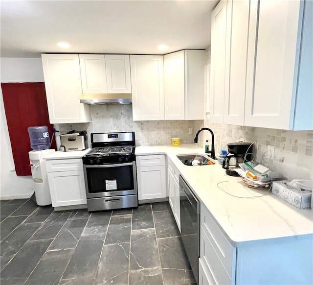 kitchen with tasteful backsplash, stainless steel gas range, sink, white cabinets, and black dishwasher