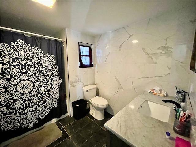 bathroom featuring vanity, curtained shower, toilet, and tile walls