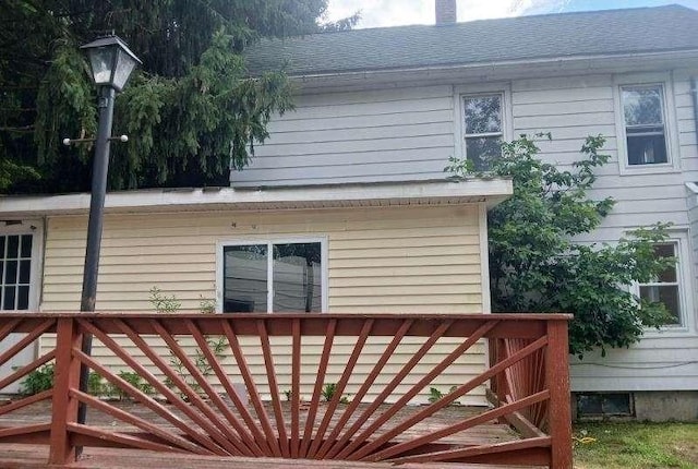 rear view of property featuring a wooden deck