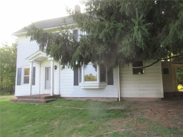 obstructed view of property with a front lawn