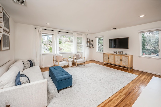 living room featuring recessed lighting, visible vents, baseboards, and wood finished floors