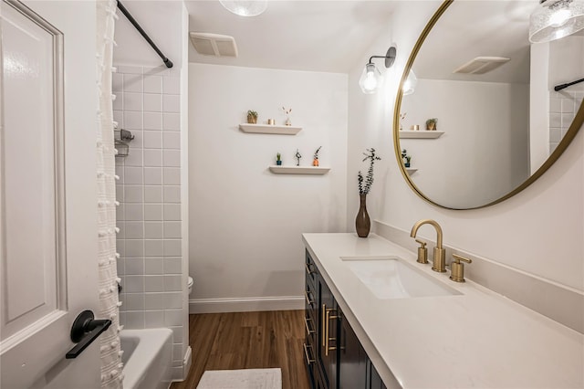 full bathroom featuring visible vents, wood finished floors, baseboards, bathtub / shower combination, and vanity