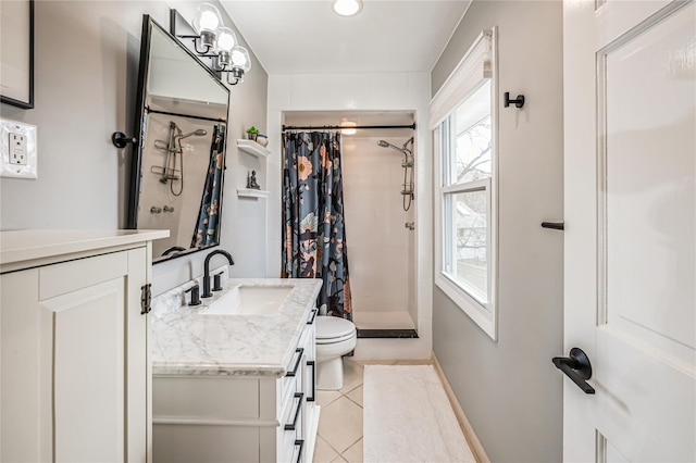 bathroom with toilet, tiled shower, tile patterned flooring, baseboards, and vanity