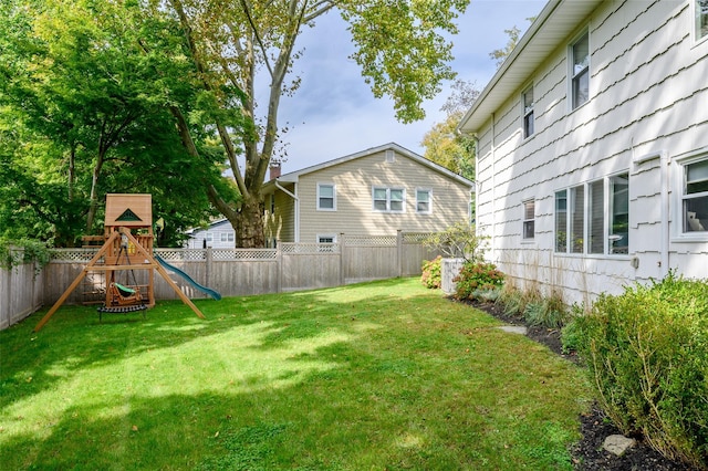 view of yard with a playground and a fenced backyard