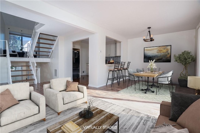 living room with hardwood / wood-style floors and an inviting chandelier